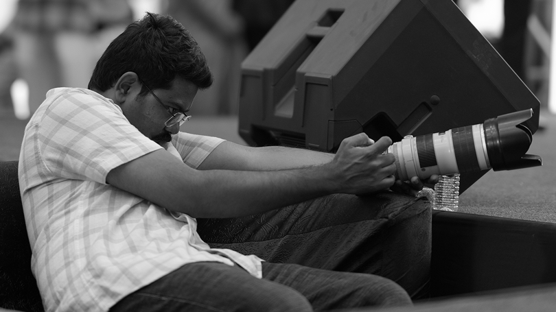 Black and white photo of Manish operating camera